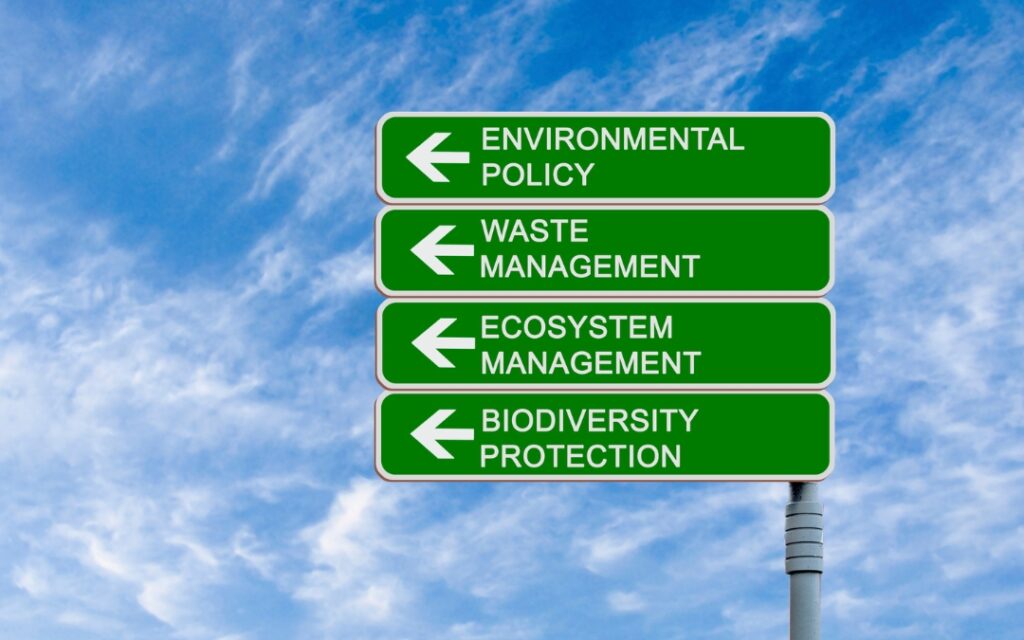 A street sign with the words environmental policy, waste management, ecosystem, and protection.