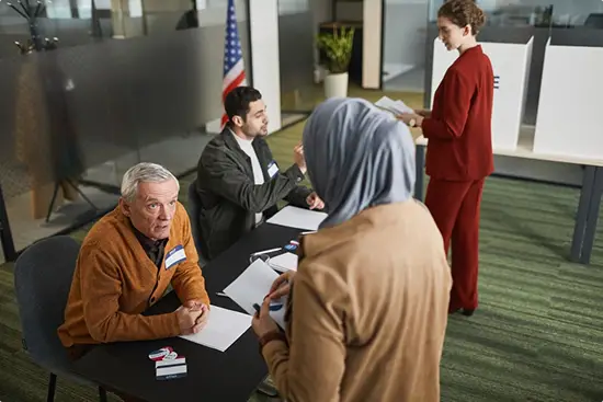 A government employee greeting constituents at a town hall to compile public feedback